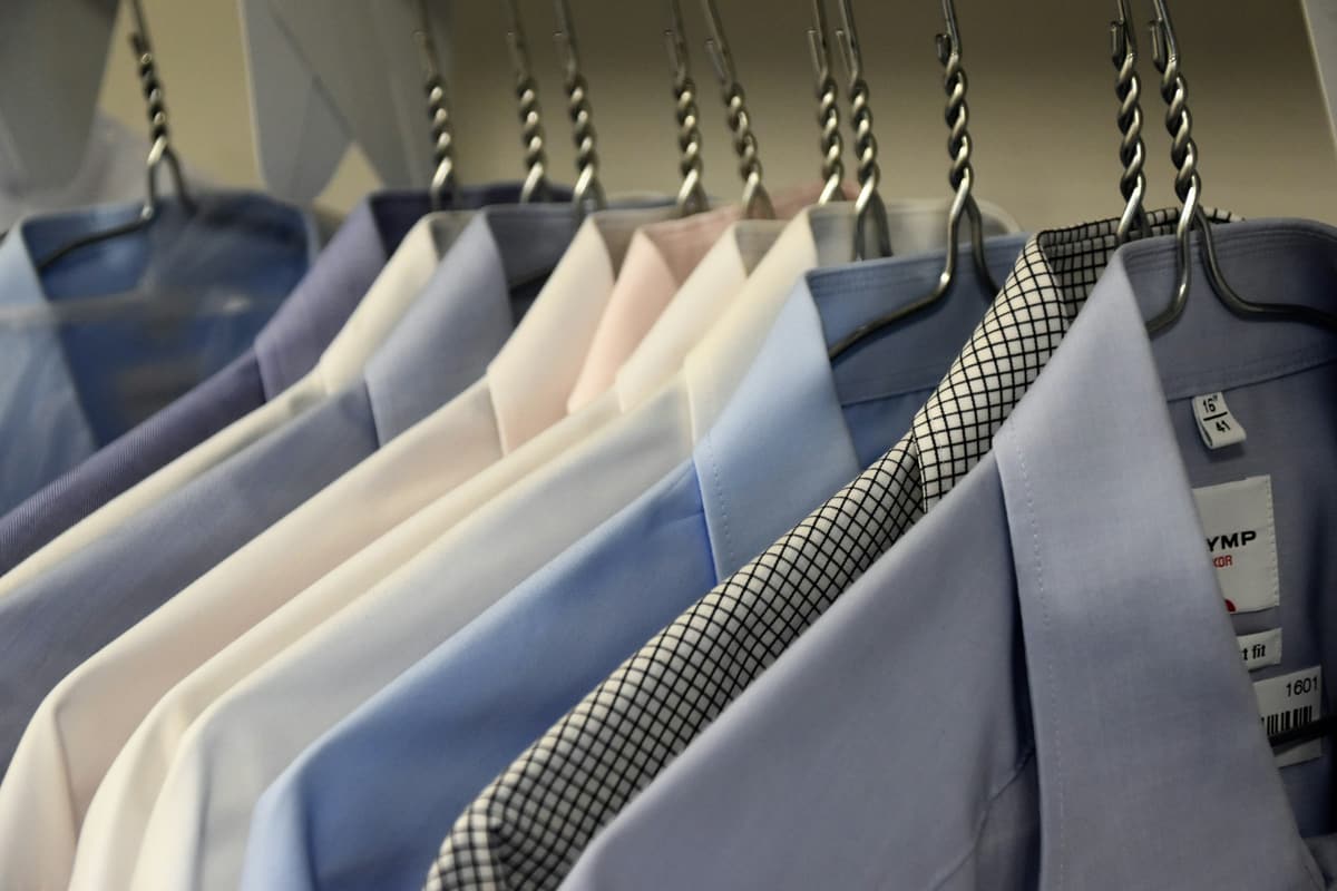 Dress shirts hanging in a row on wire hangers
